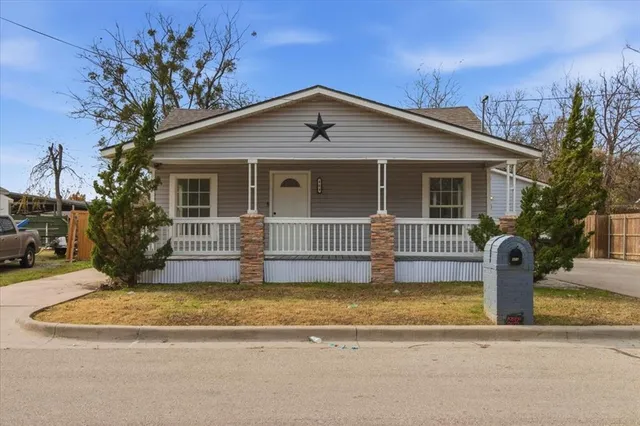 a front view of house with yard and trees around