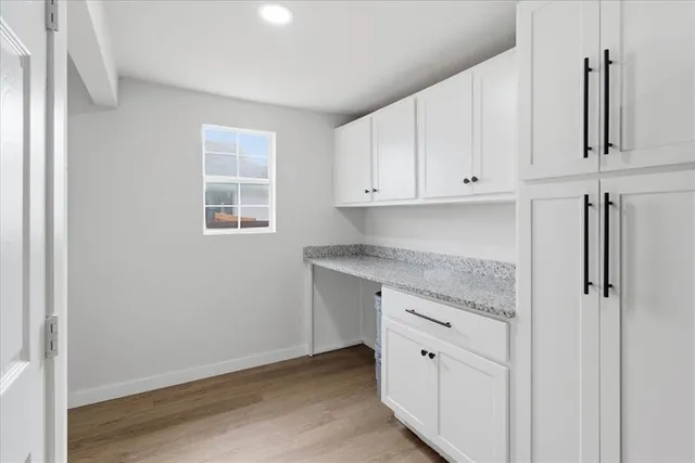 a kitchen with granite countertop white cabinets and white appliances