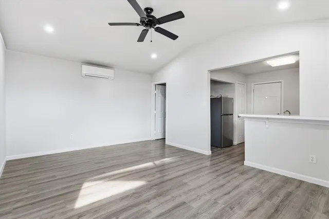 a view of empty room with wooden floor and window