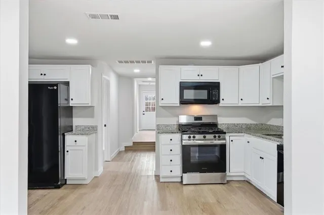 a kitchen with stainless steel appliances a stove top oven and refrigerator