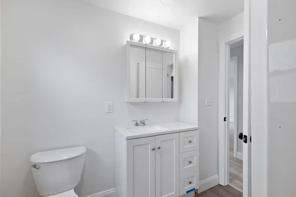 a bathroom with a toilet a sink and mirror