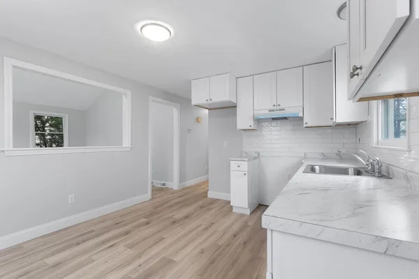 a kitchen with granite countertop white cabinets and white appliances