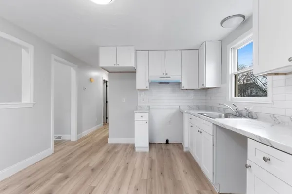 a kitchen with cabinets appliances and a wooden floor