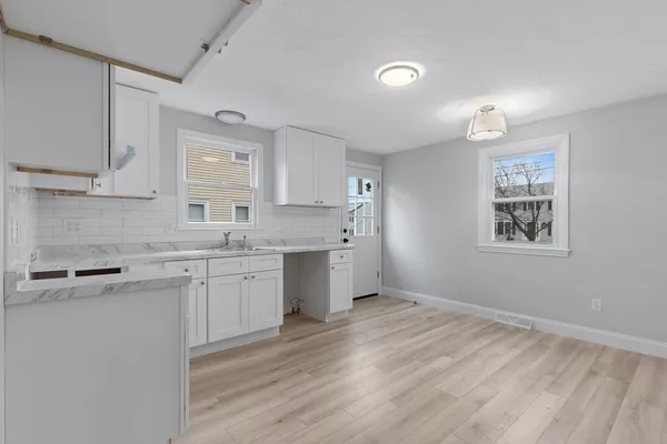 a kitchen with a sink cabinets and wooden floor