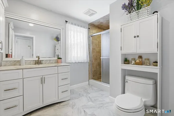 a spacious bathroom with a toilet a sink and a mirror