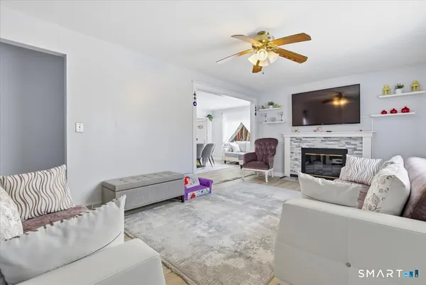 a living room with furniture a flat screen tv and a fireplace