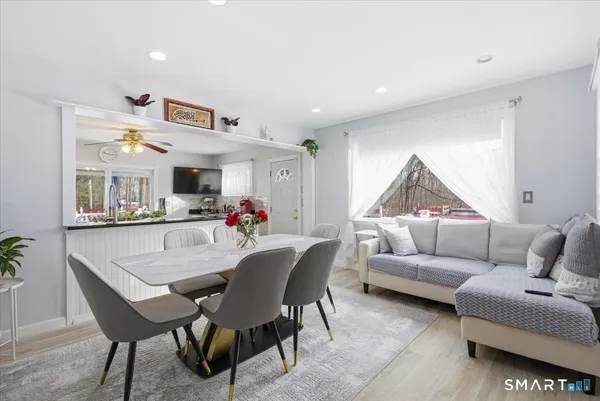 a living room with furniture kitchen view and a chandelier