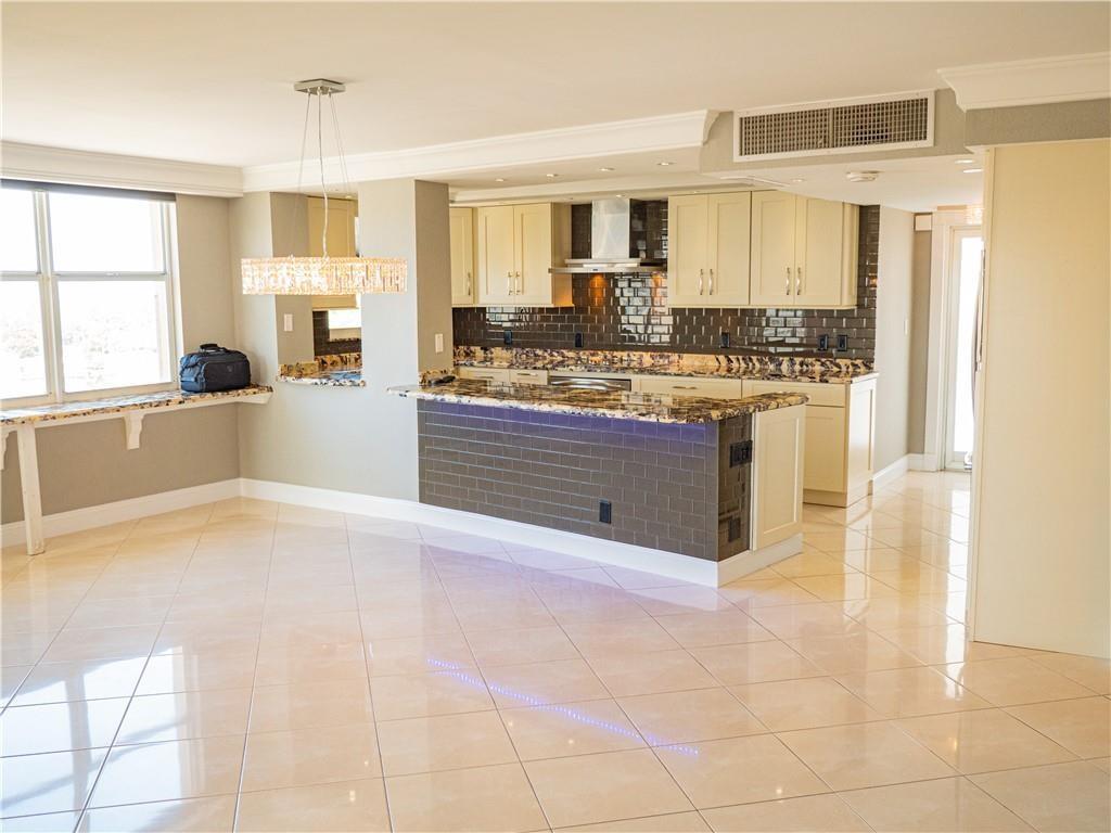 328 North Ocean Boulevard, Unit 1008 Pompano Beach, FL 33062 - Photo 11 of 38 a large kitchen with kitchen island a sink stainless steel appliances and cabinets