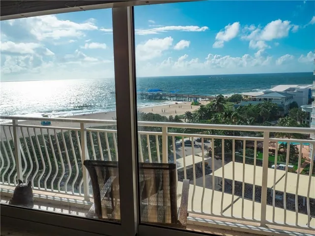 a view of a balcony with wooden floor & fence and city view