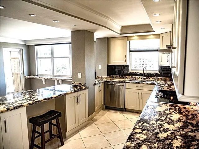 a kitchen with kitchen island granite countertop a stove and a refrigerator