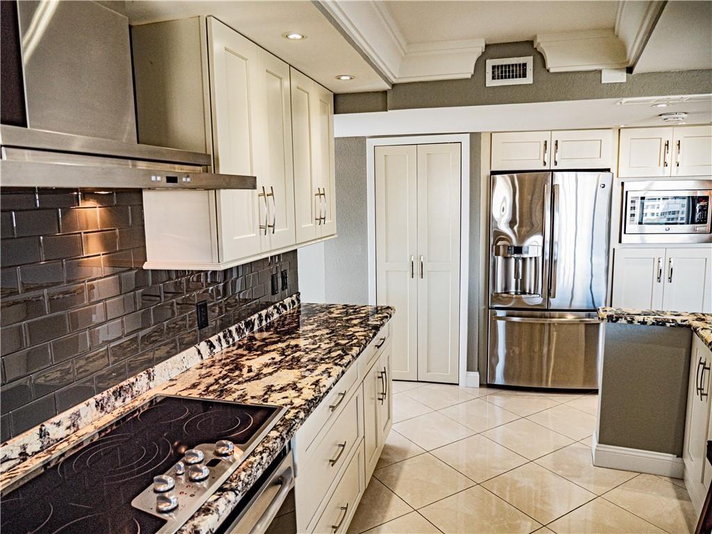 328 North Ocean Boulevard, Unit 1008 Pompano Beach, FL 33062 - Photo 8 of 38 a kitchen with kitchen island granite countertop a stove and a refrigerator
