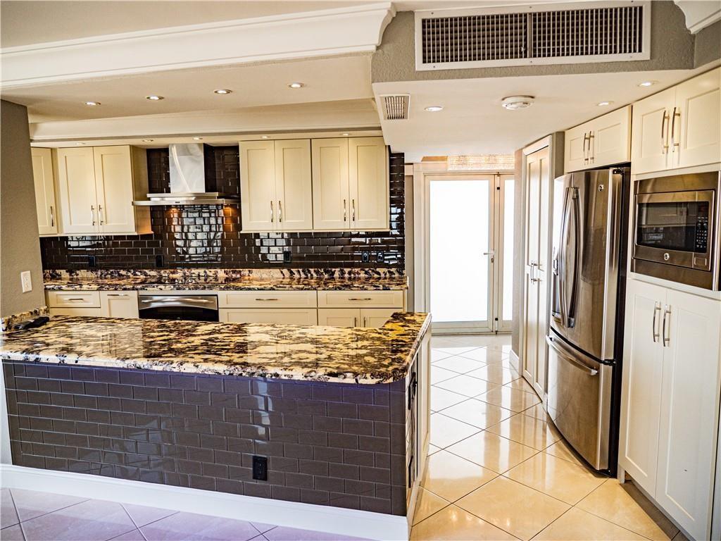 328 North Ocean Boulevard, Unit 1008 Pompano Beach, FL 33062 - Photo 9 of 38 a kitchen with stainless steel appliances granite countertop a refrigerator and a counter space