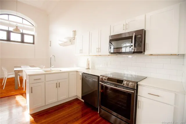 a kitchen with stainless steel appliances a stove microwave and sink