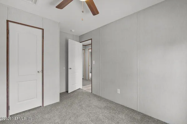 an empty room with chandelier fan