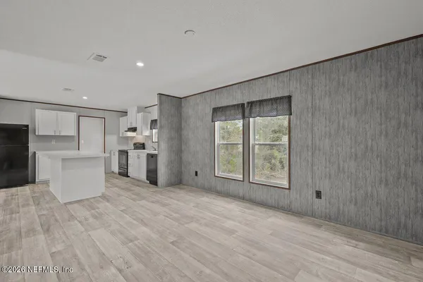 a view of a kitchen with microwave and refrigerator