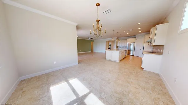 a view of a kitchen with kitchen island a sink wooden floor and a refrigerator