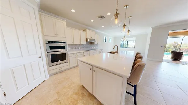 a kitchen with stainless steel appliances a stove a sink a microwave a dining table and chairs
