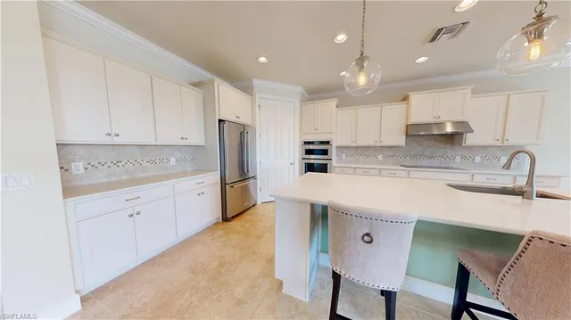 a kitchen with a refrigerator a sink and cabinets