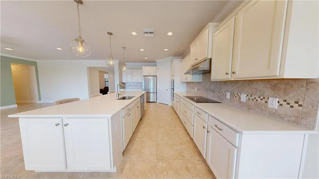 a large white kitchen with a sink and dishwasher