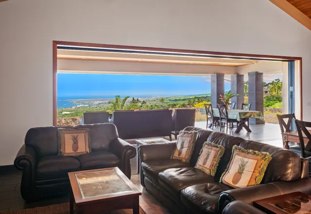 a living room with furniture and floor to ceiling windows