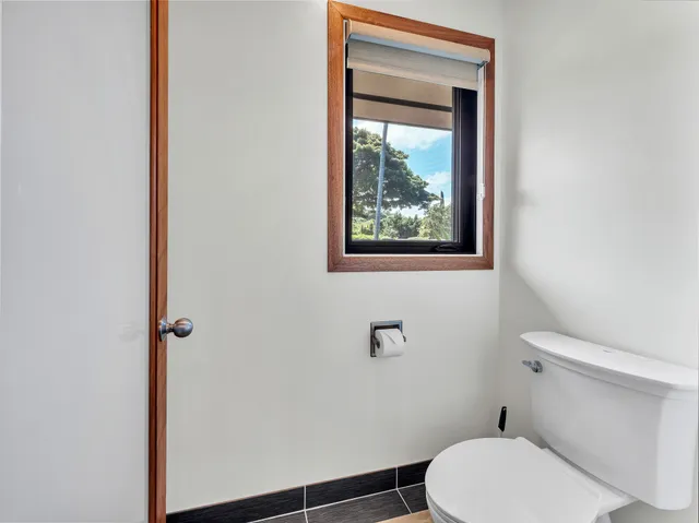 a white toilet sitting next to a small window