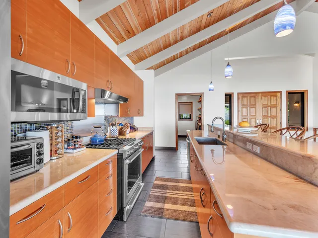 a large kitchen with stainless steel appliances granite countertop a lot of counter space and wooden floor