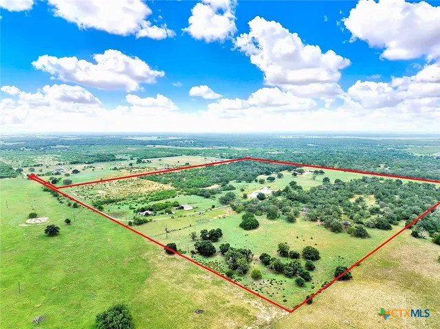 a kitchen with stainless steel appliances kitchen island granite countertop a dining table chairs and a refrigerator