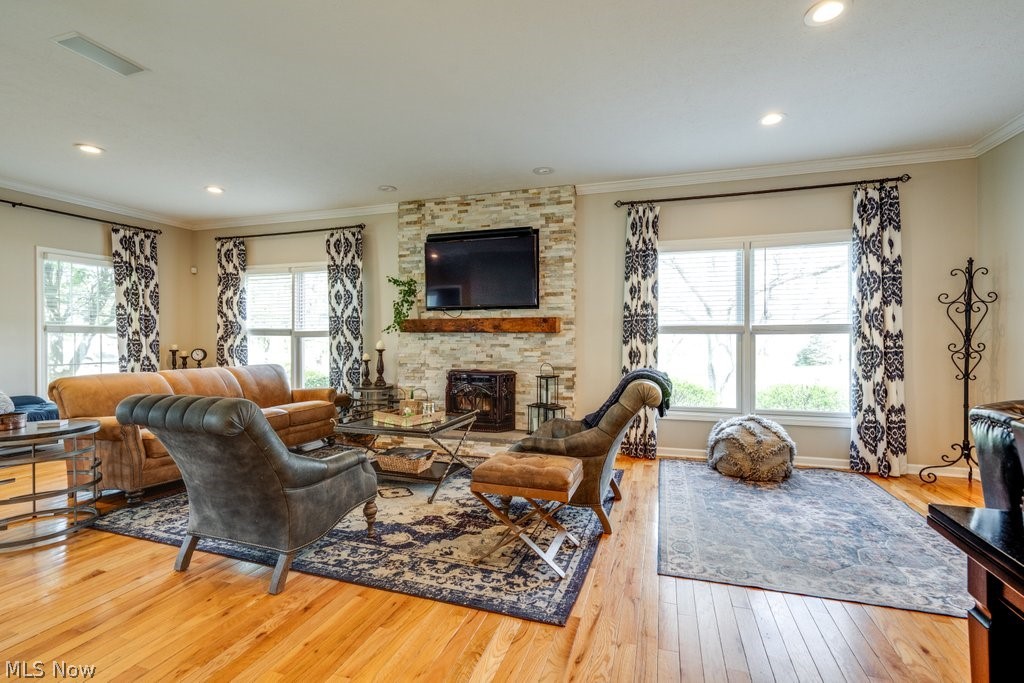 6325 Brecksville Road Independence, OH 44131 - Photo 10 of 50 Living area featuring hardwood floors, a stone fireplace, and windows providing natural light