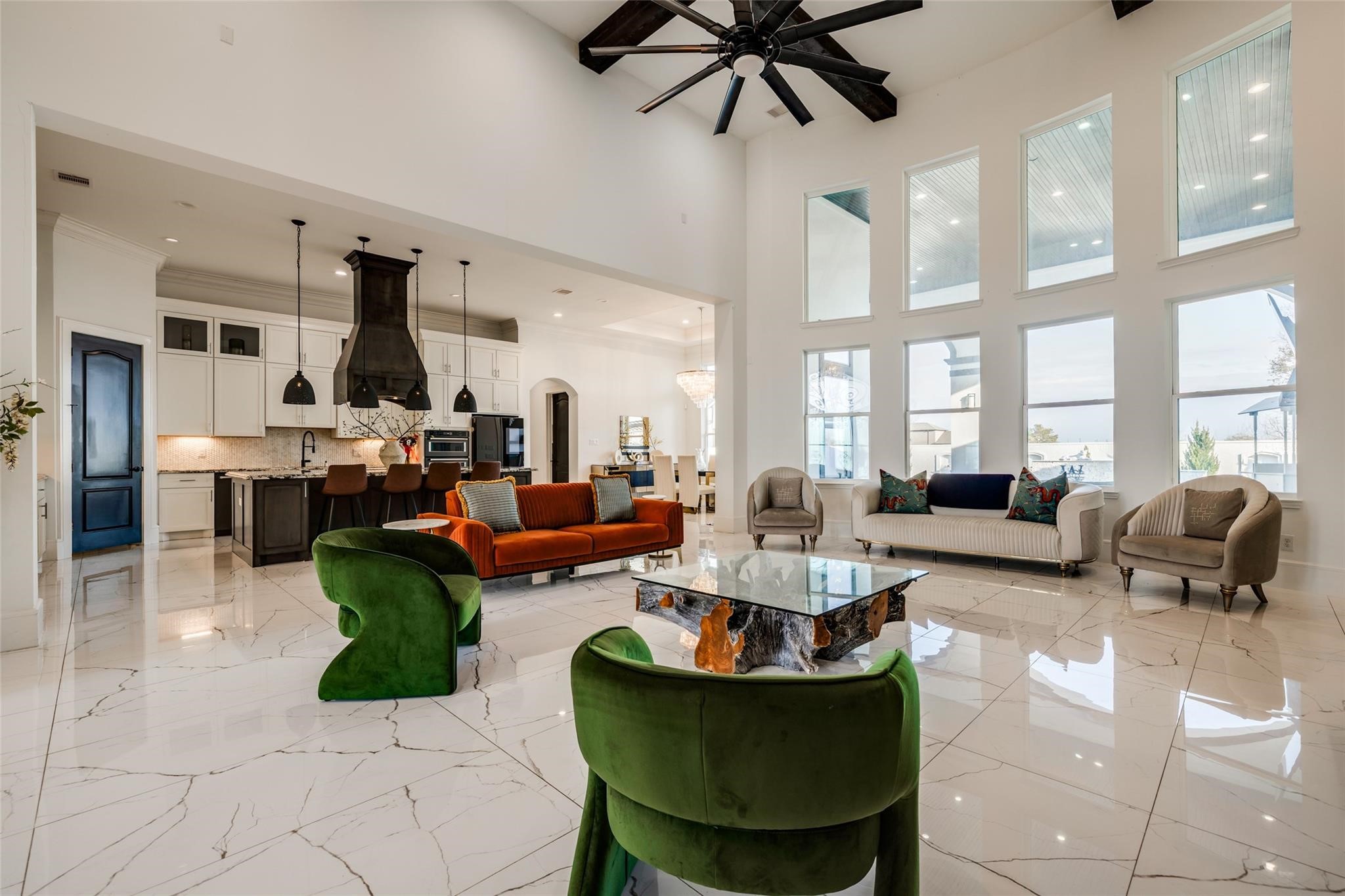 4821 Walters Road Richmond, TX 77469 - Photo 21 of 50 a perfect blend of modern luxury and warmth, highlighted by soaring vaulted ceilings with exposed beams, oversized windows that flood the home with natural light, and elegant designer finishes throughout. The open-concept layout features a striking floor-to-ceiling fireplace, custom built-ins, and seamless flow into the gourmet kitchen and dining areas, creating an ideal setting for both everyday living and entertaining. Thoughtfully curated furnishings, rich wood accents, and sophisticated lighting