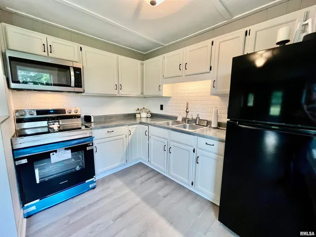 a kitchen with stainless steel appliances a stove microwave and sink