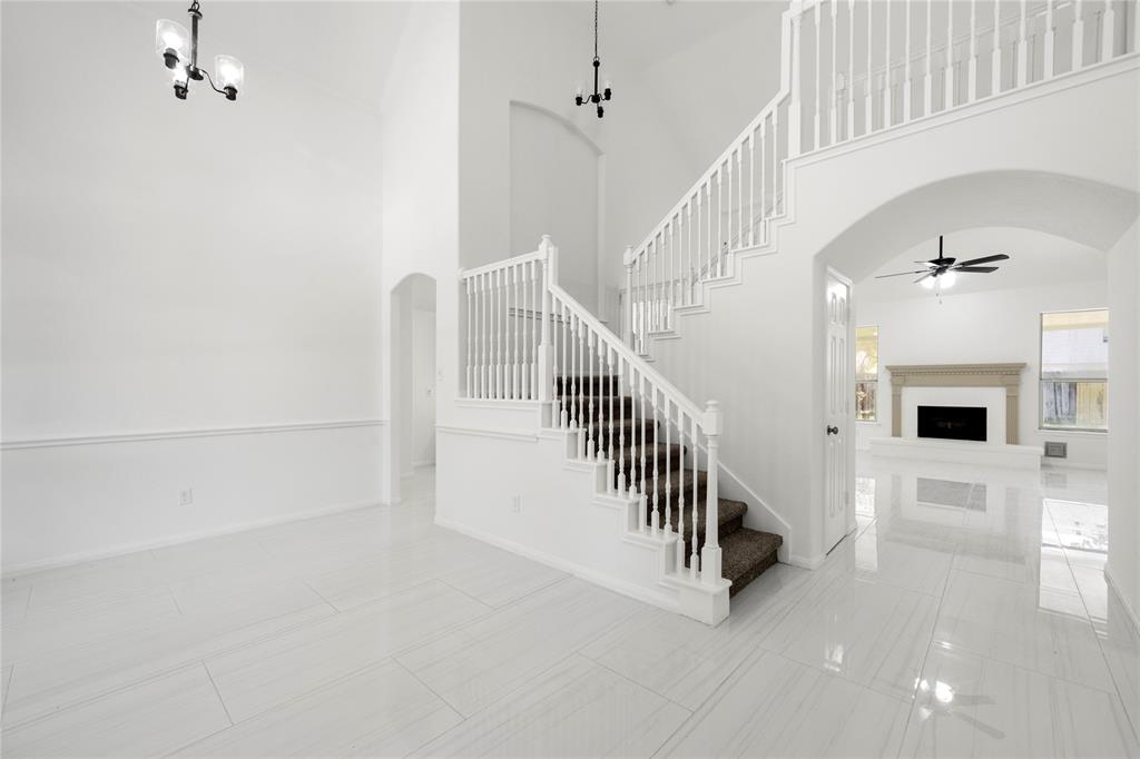 a view of staircase with white walls and a rug