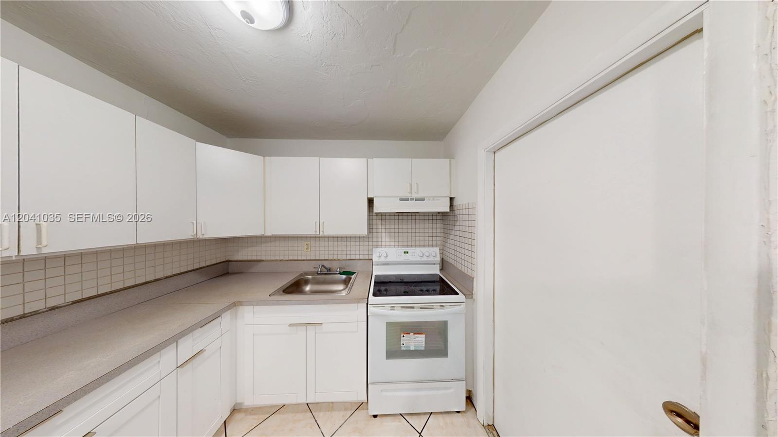 6811 Southwest 16th Street Miami, FL 33144 - Photo 3 of 21 a kitchen with a stove cabinets and a sink