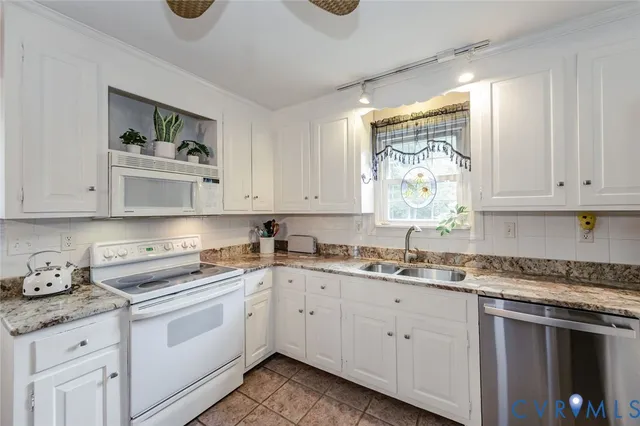 a kitchen with cabinets appliances a sink and a window