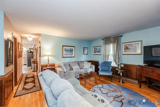 a living room with furniture and a flat screen tv with wooden floor