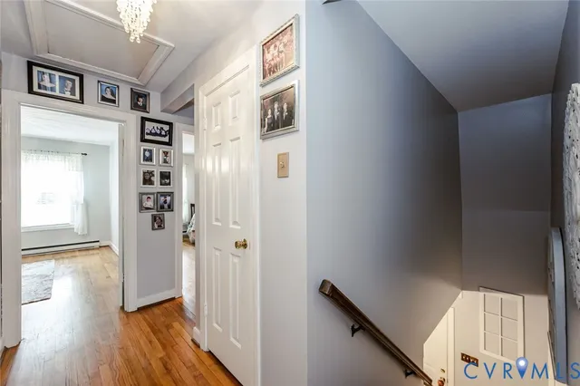 a view of a hallway with wooden floor and staircase