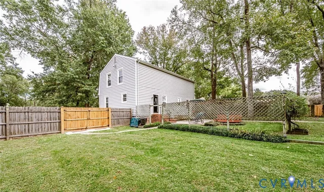 a view of backyard with tree and wooden fence