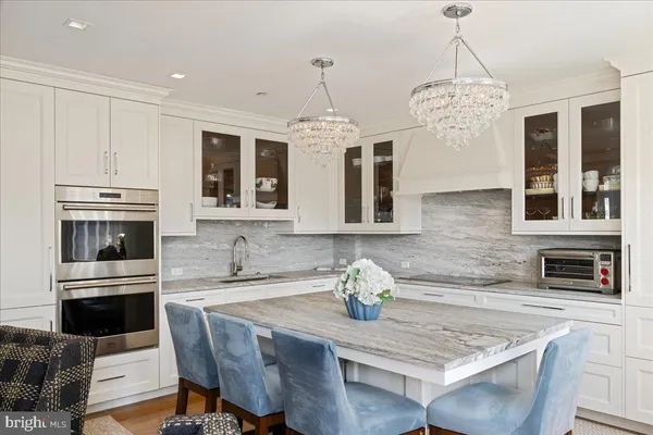 a kitchen with granite countertop a stove a sink a dining table and chairs