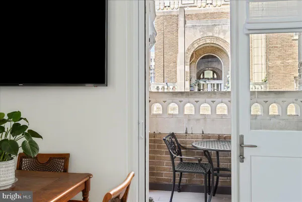 a living room with furniture a large window and potted plants