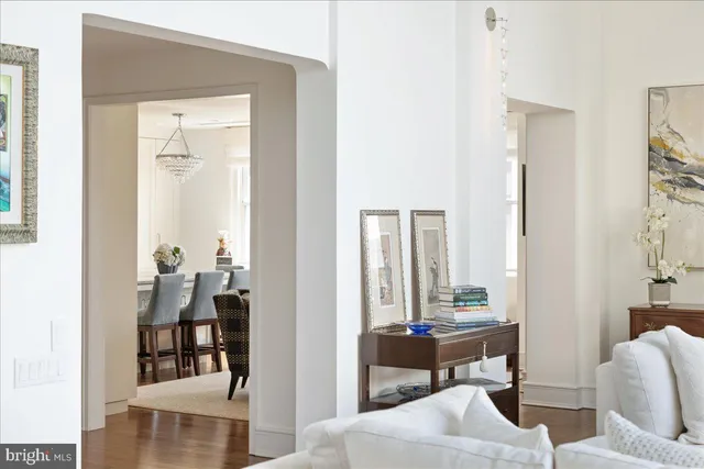 a kitchen with stainless steel appliances granite countertop a stove top oven a sink dishwasher a dining table and chairs with wooden floor