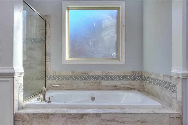a bathroom with bathtub and window