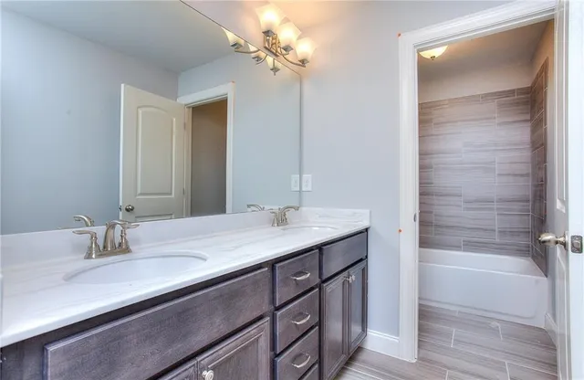 a bathroom with a granite countertop sink a large mirror and a bathtub