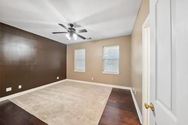 a view of street with a small yard and wooden fence