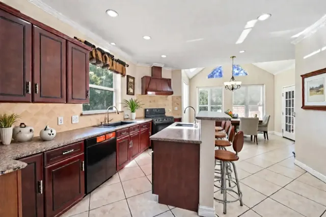 a view of a big house with large trees and plants