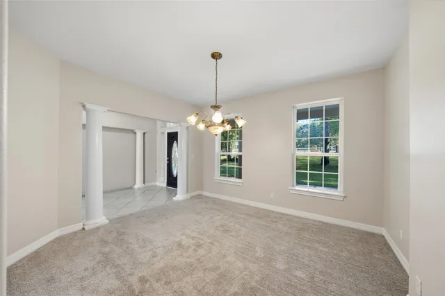 a dining hall with stainless steel appliances granite countertop a rug a stove and a window