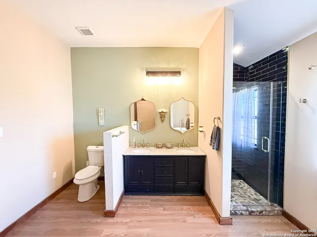 a bathroom with a granite countertop sink a toilet and a mirror