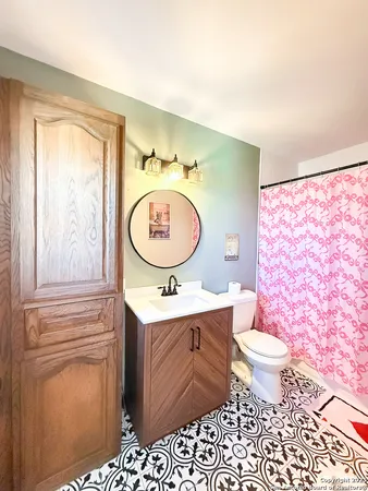 a bathroom with a toilet a sink and a mirror