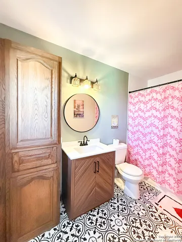 a bathroom with a toilet a sink and a mirror