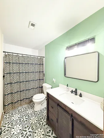 a bathroom with a sink mirror toilet and shower