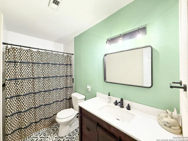 a bathroom with a sink toilet mirror and shower