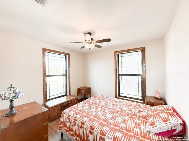 a bedroom with a bed and a window with a chair